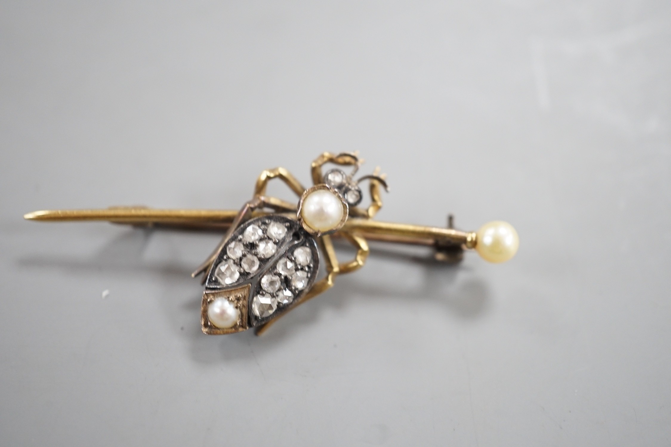 An early 20th century white and yellow metal, rose cut diamond and split pearl cluster set bug bar brooch, 49mm, gross weight 4.6 grams.